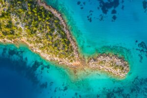 Aerial view of clear turquoise water near a tropical island in the Caribbean